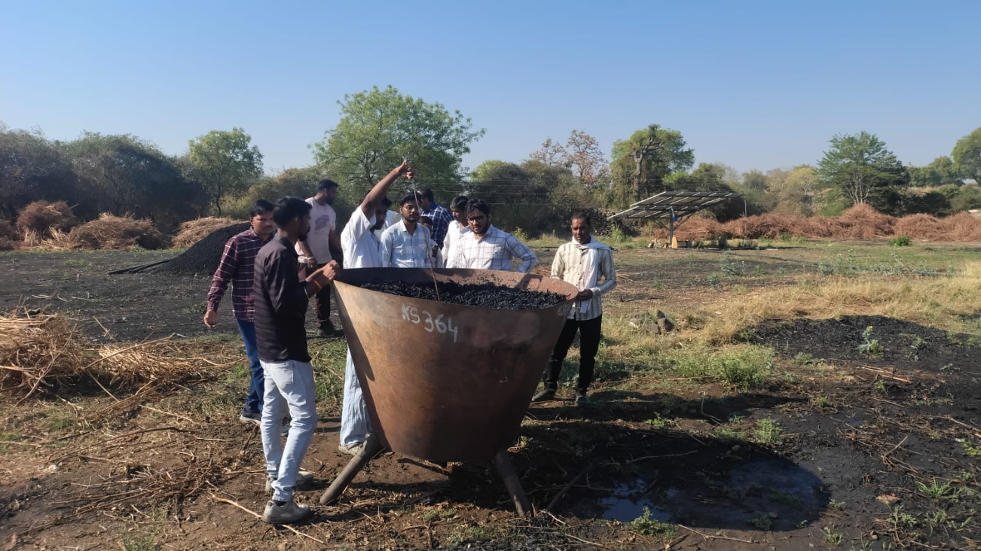 Researchers and stakeholders inspecting a biochar kiln on a CSR site visit